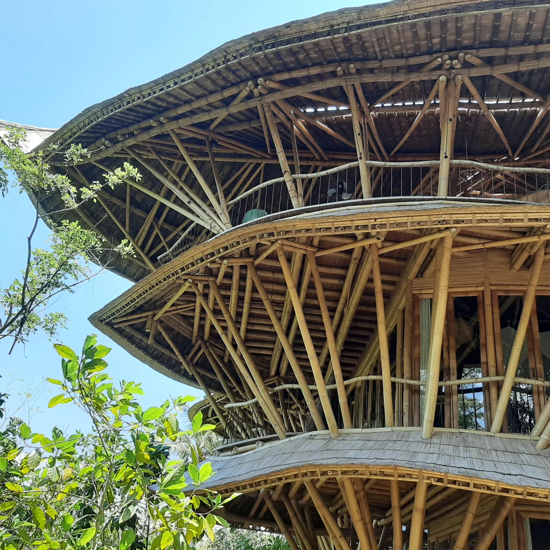 Curving balconies and structural bamboo poles at Sharma Springs in Bali.