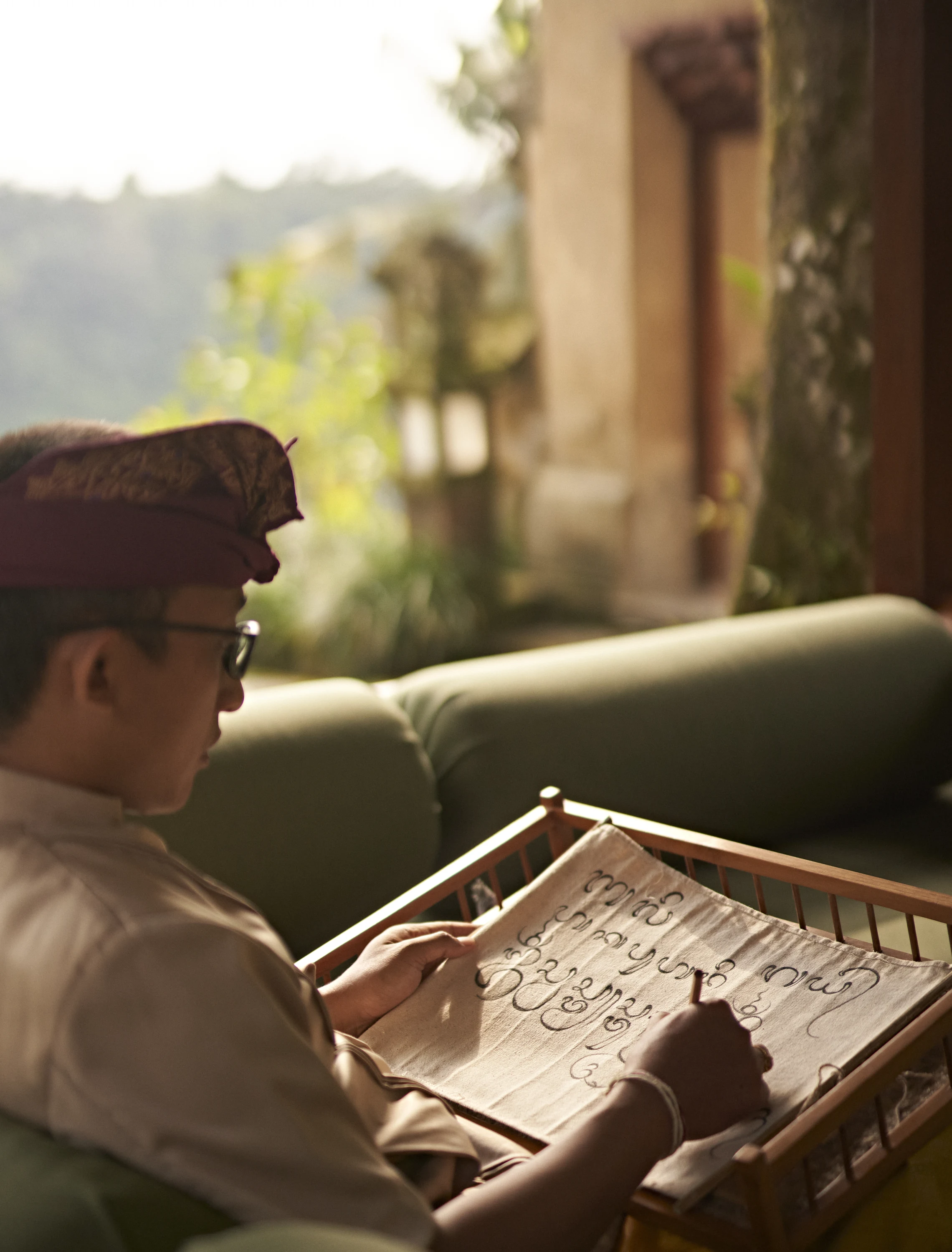 A participant practising Balinese script with a stylus at Amandari.