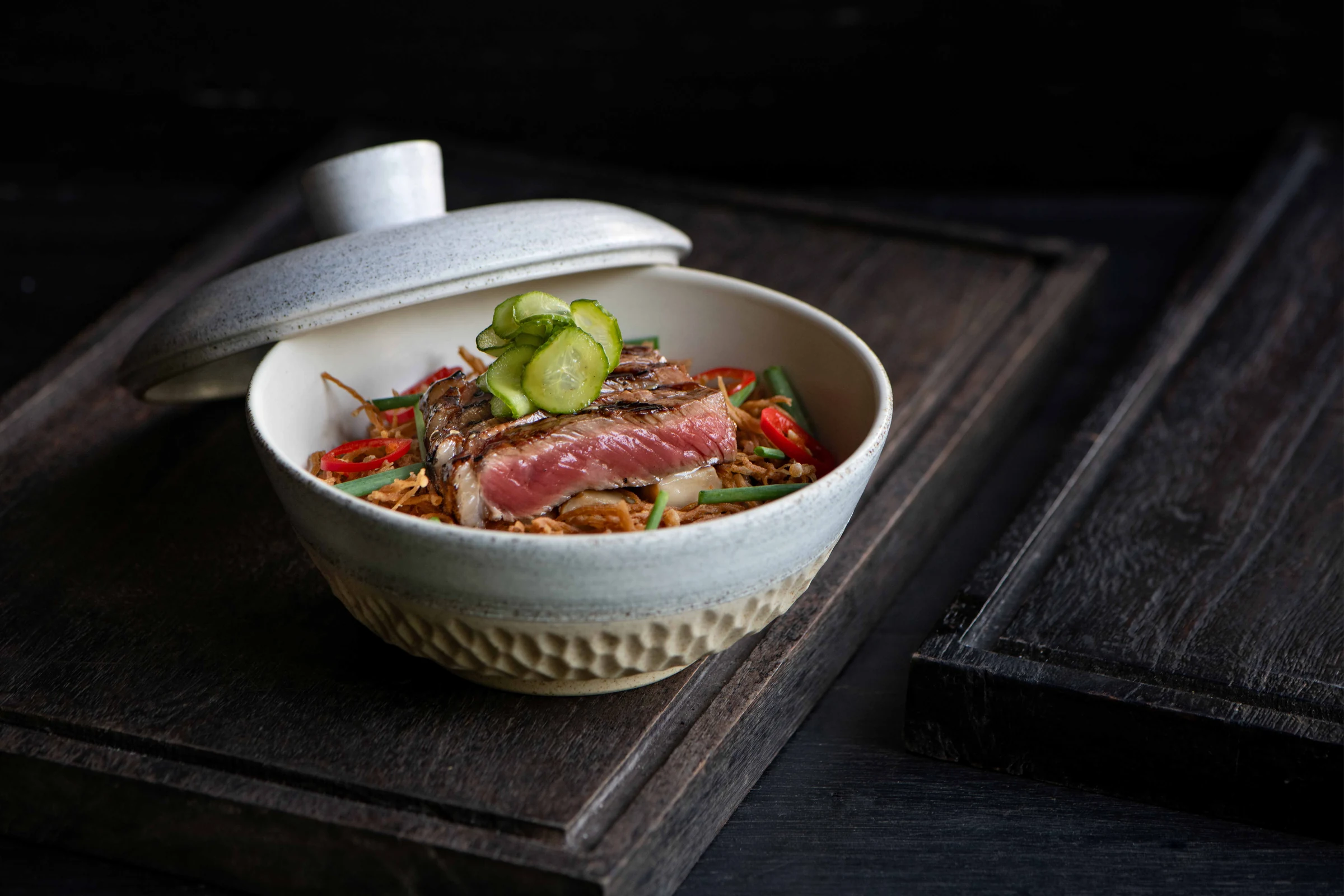 A carefully plated meat dish in a ceramic bowl at Api Jiwa