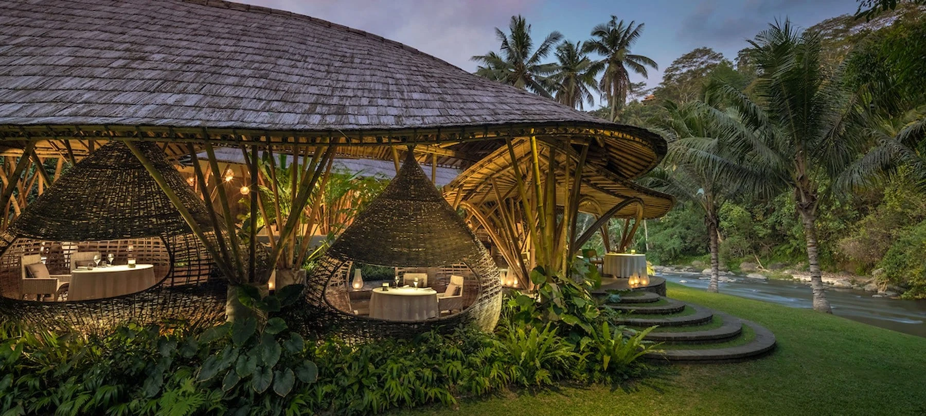 Kubu’s illuminated bamboo dining cocoons beside the Ayung River