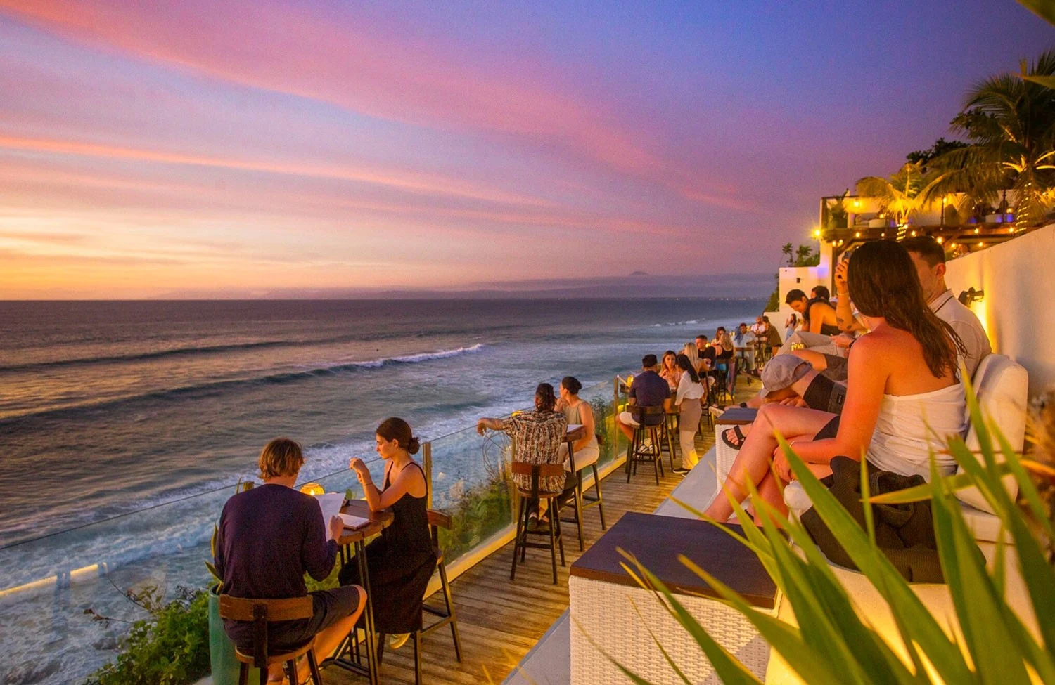 Guests watching a pink sunset from the ocean-facing terrace at El Kabron.