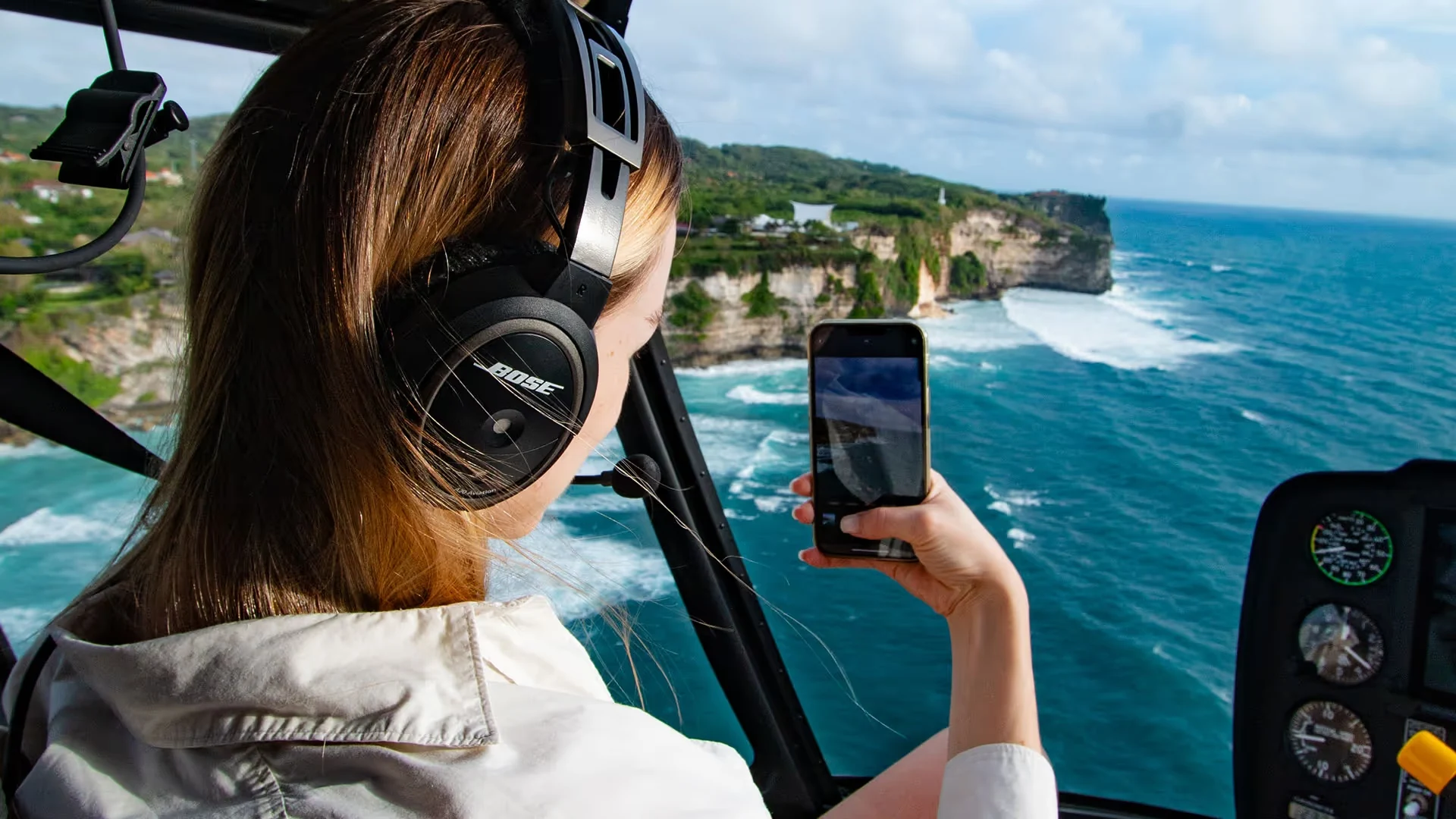 A passenger views the Uluwatu coastline from a Balicopter helicopter.