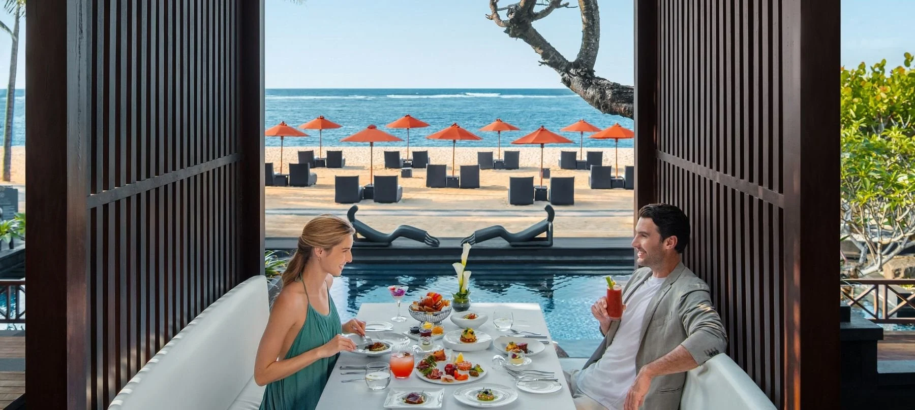 A couple enjoying brunch with ocean views at Kayuputi.
