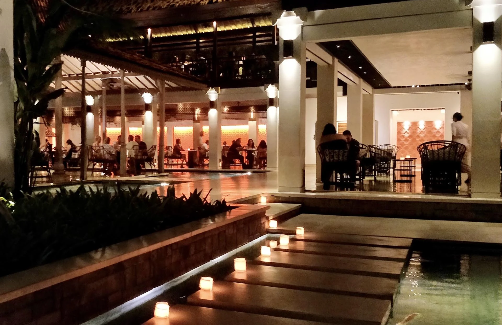 Bambu’s evening dining pavilions and candlelit walkway over reflecting pools.
