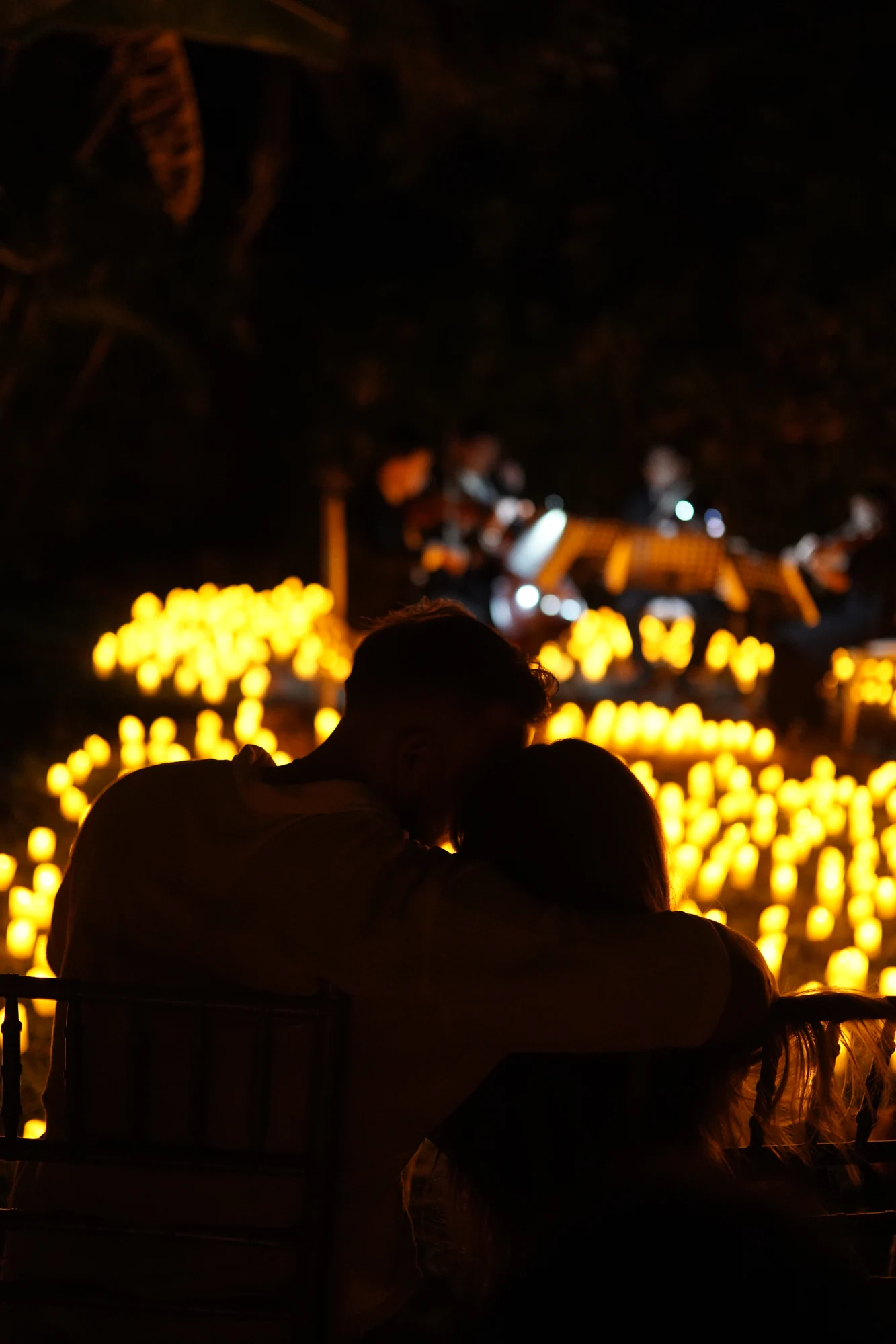 Guests sit among candle lights for an intimate Firefly concert in Bali.