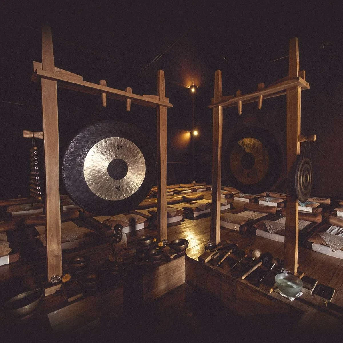 Gongs and sound instruments arranged inside the dimly lit pyramid at Pyramids of Chi.