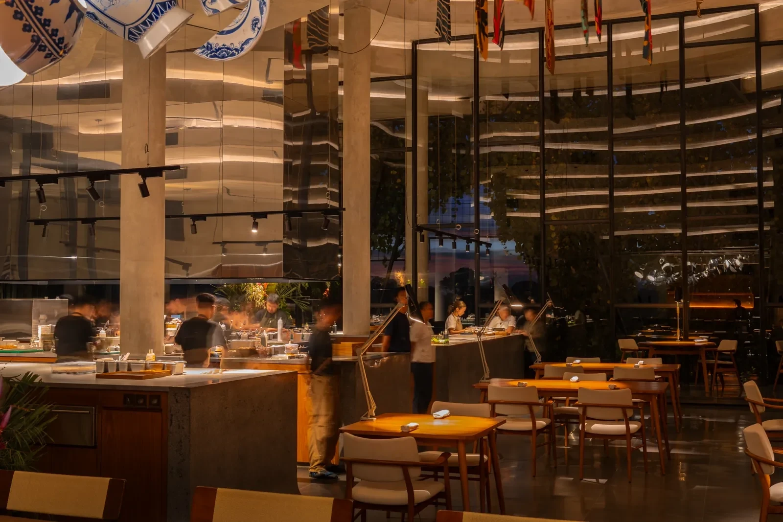 Warmly lit tables and the open kitchen in Locavore NXT’s dining room in Lodtunduh, Ubud.