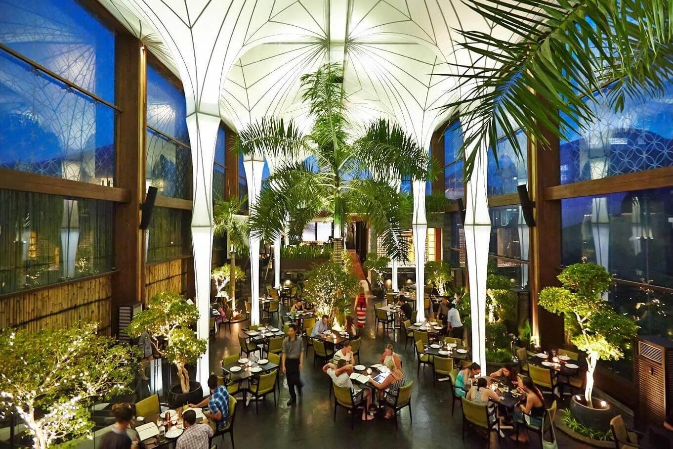Merah Putih dining room with tall white columns and tropical palms.