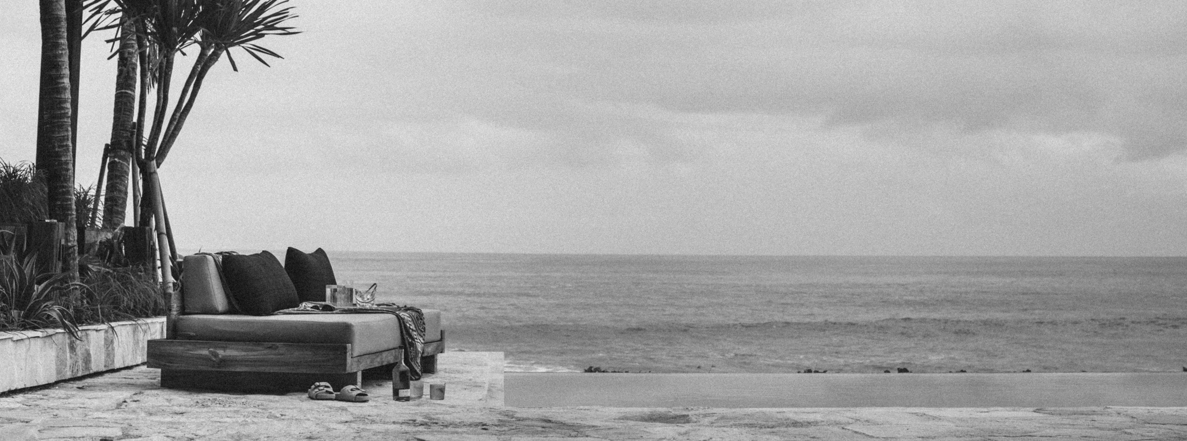 Black-and-white panorama of oceanfront daybeds at The Lawn.