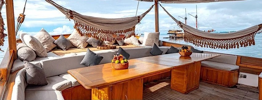 Anne Bonny wooden foredeck with cushioned seating beneath the rigging