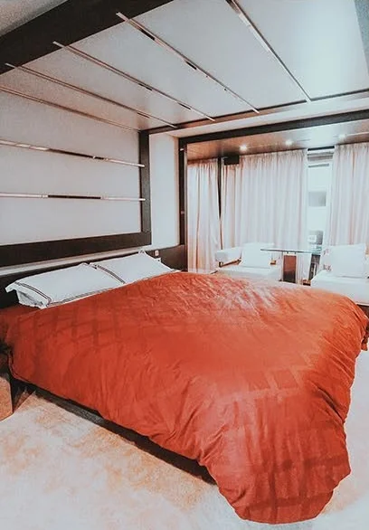 Azimut 103 double cabin with orange bedding and dark wood trim