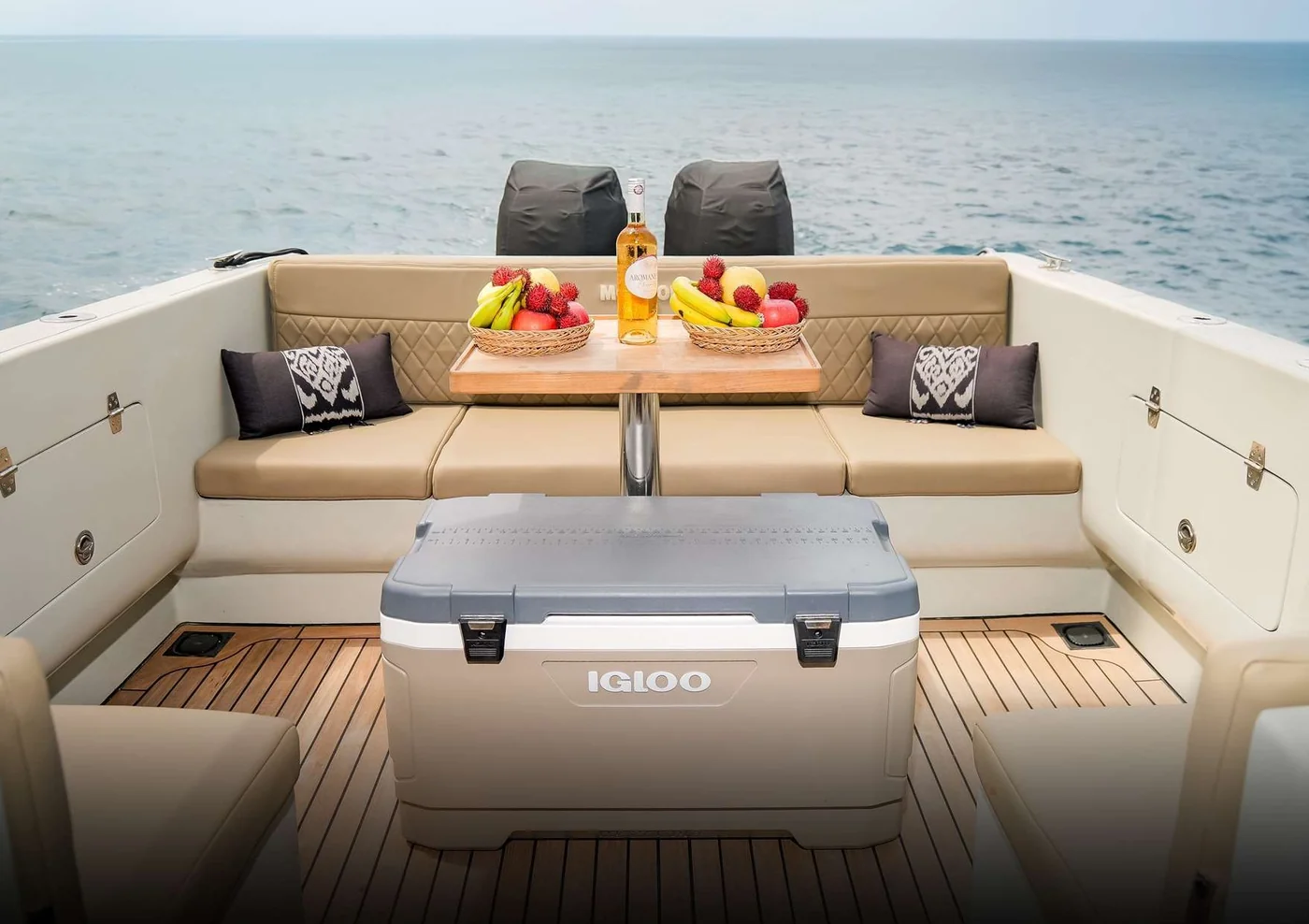 Moyo One open aft seating with pale cushions and a low table
