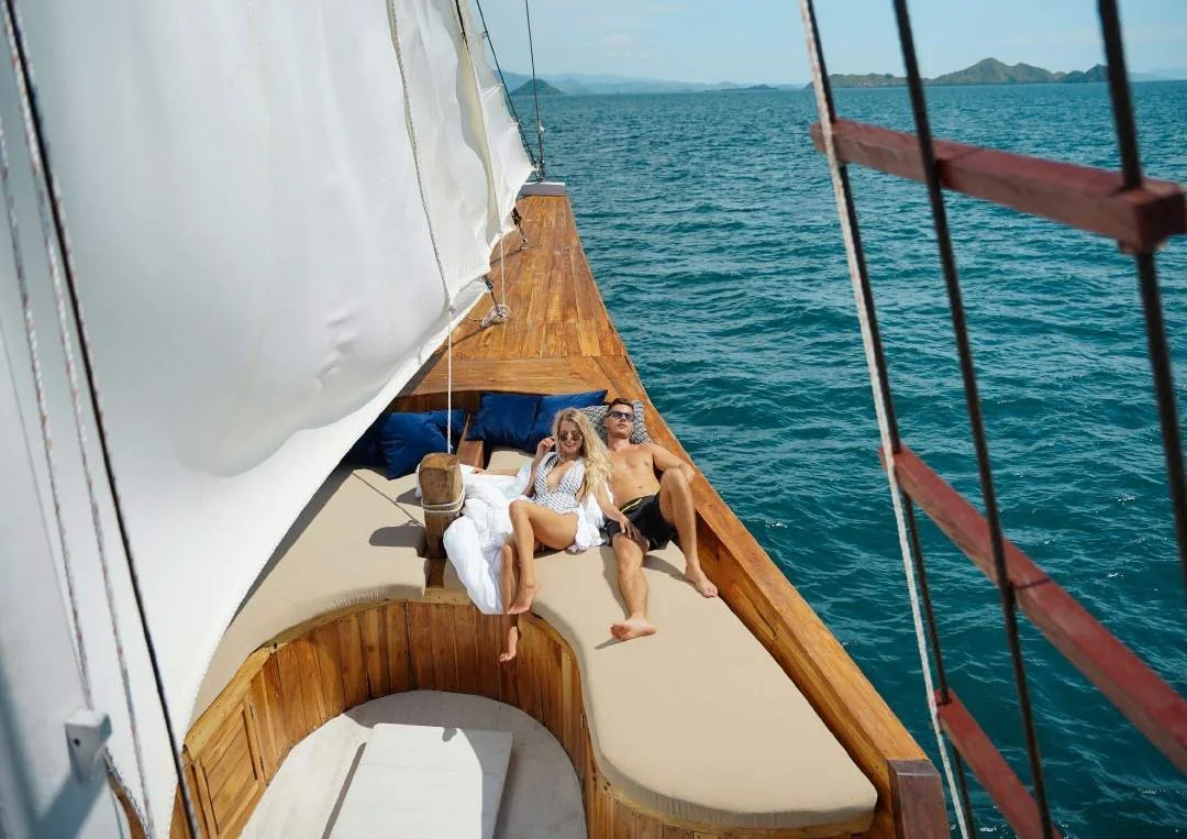 Raffles wooden foredeck with seating beneath white sails