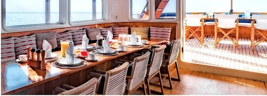 Rascal dining salon with timber finishes and wide sea-view windows