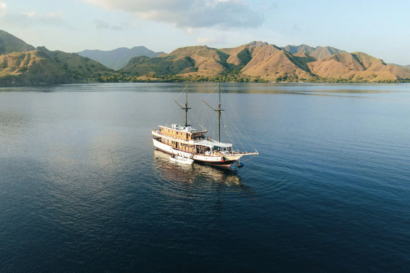 Samara I at anchor in a calm bay surrounded by island hills