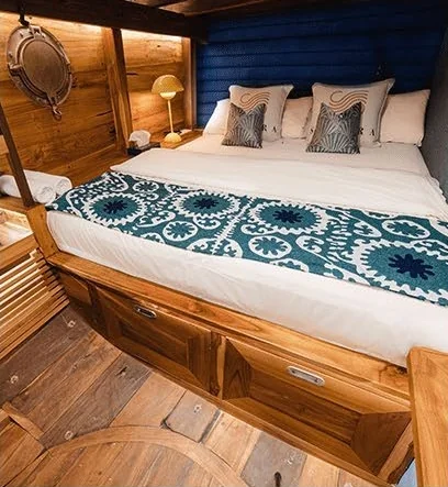 Samara II timber cabin with blue headboard and patterned bedding